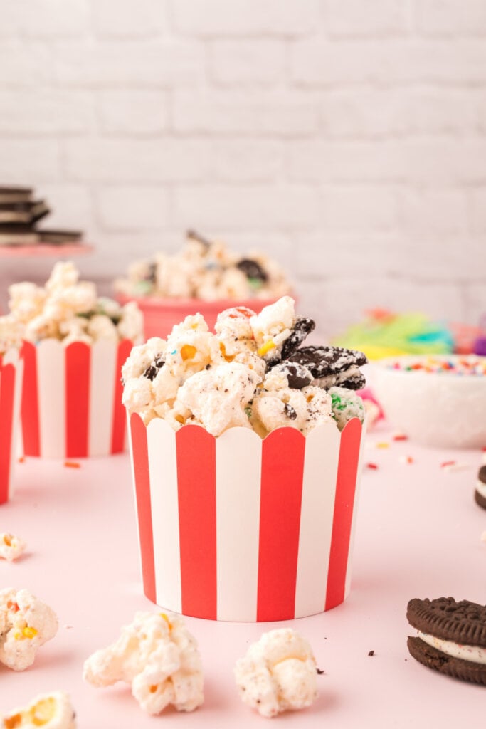 small striped party cup with popcorn snack mix