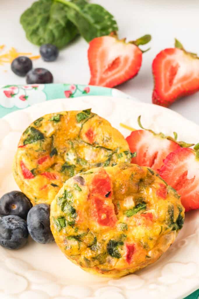 Close-up of Breakfast Egg Muffins with spinach, roasted red peppers, strawberries, and blueberries