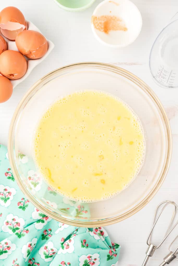 Whisked egg mixture in a glass bowl for Breakfast Egg Muffins