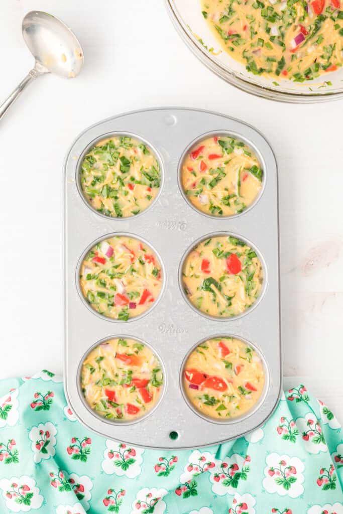Unbaked Breakfast Egg Muffins in a muffin pan before baking