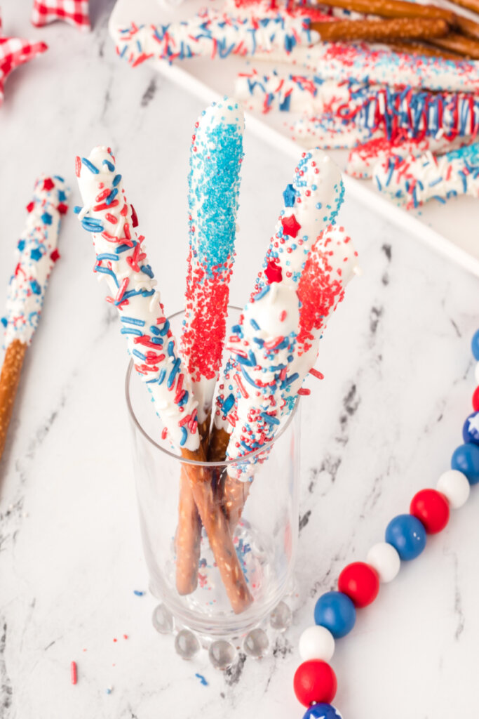 assorted candy dipped pretzel rods in glass jar