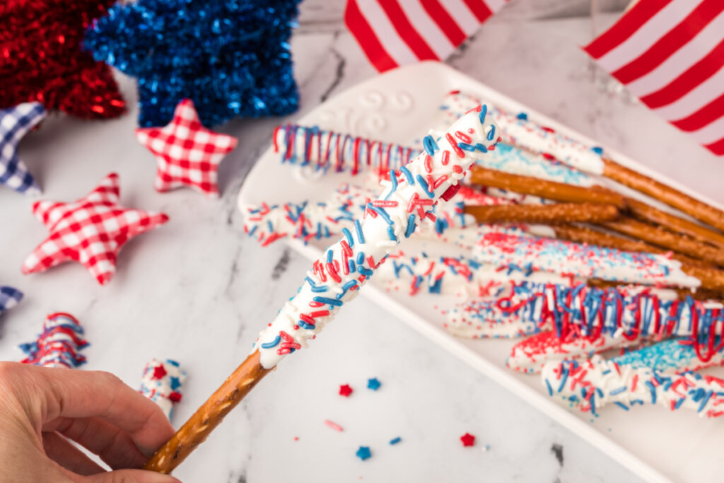 hand holding chocolate covered pretzel rod