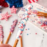 hand holding chocolate covered pretzel rods