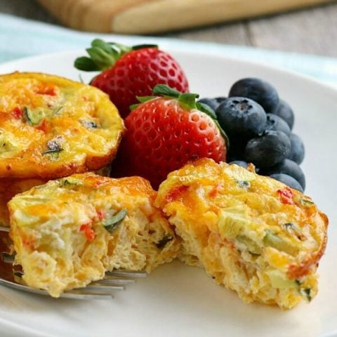 closeup of breakfast egg muffin on plate with fruit