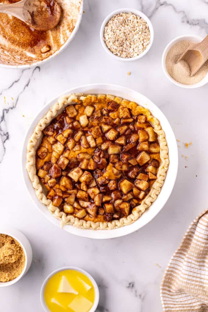 Pumpkin layer topped with cinnamon coated apples inside a pie crust.