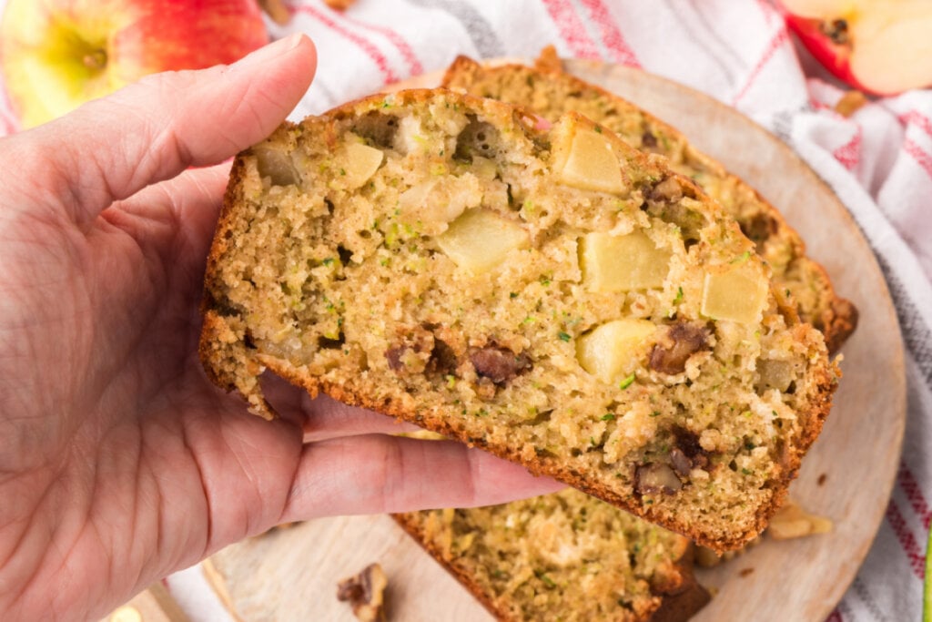 hand holding slice of apple zuchhini bread