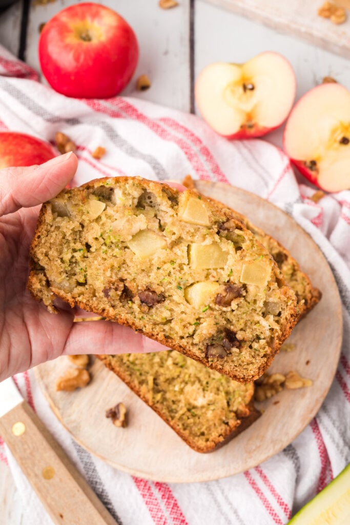 hand holding a slice of apple zucchin bread