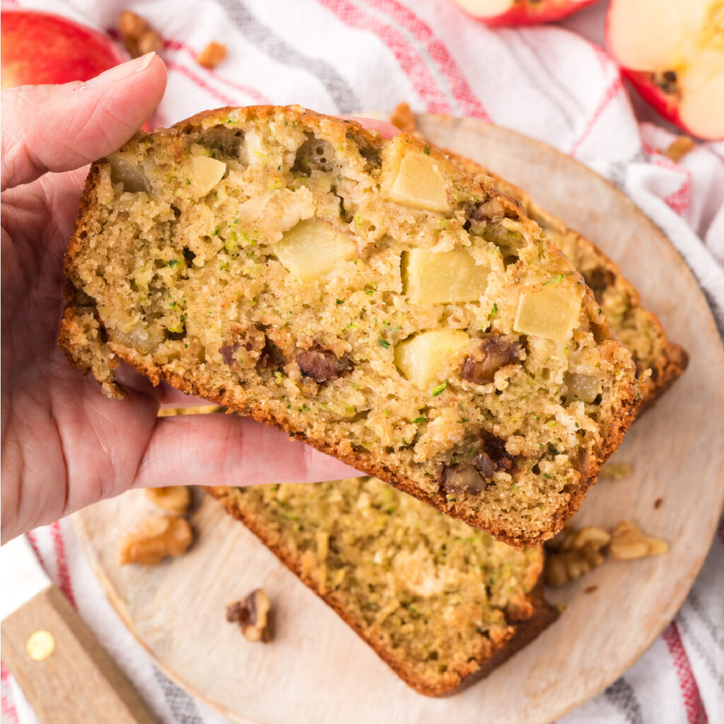 hand holding a slice of apple zucchini bread