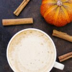 Pumpkin Chai Tea Latte with sticks of cinnamon and a pumpkin.