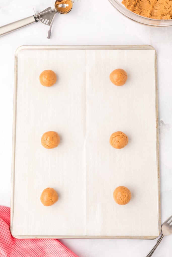 raw Biscoff Butter Cookies dough balls arranged on a baking sheet before baking
