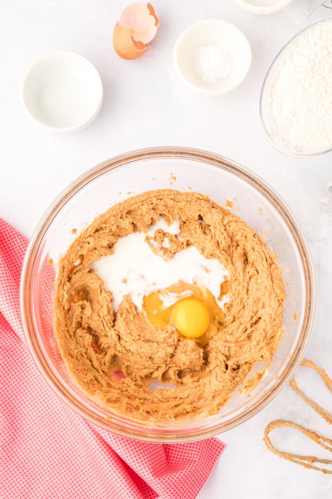 Biscoff Butter Cookies dough with egg and milk added in a glass mixing bowl