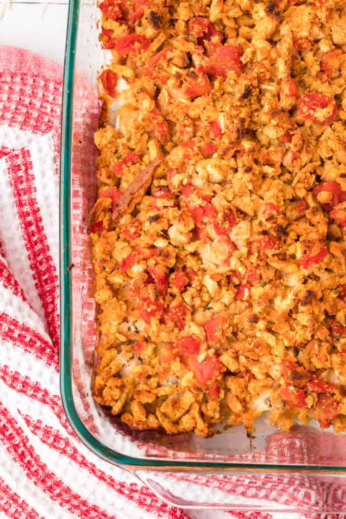 Close-up of baked Chicken Bruschetta Bake showing the golden stuffing topping, tomatoes, and melted cheese in the casserole dish.