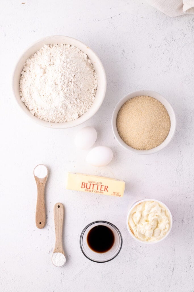 Overhead view of ingredients for Italian Ricotta Cookies arranged on a white surface
