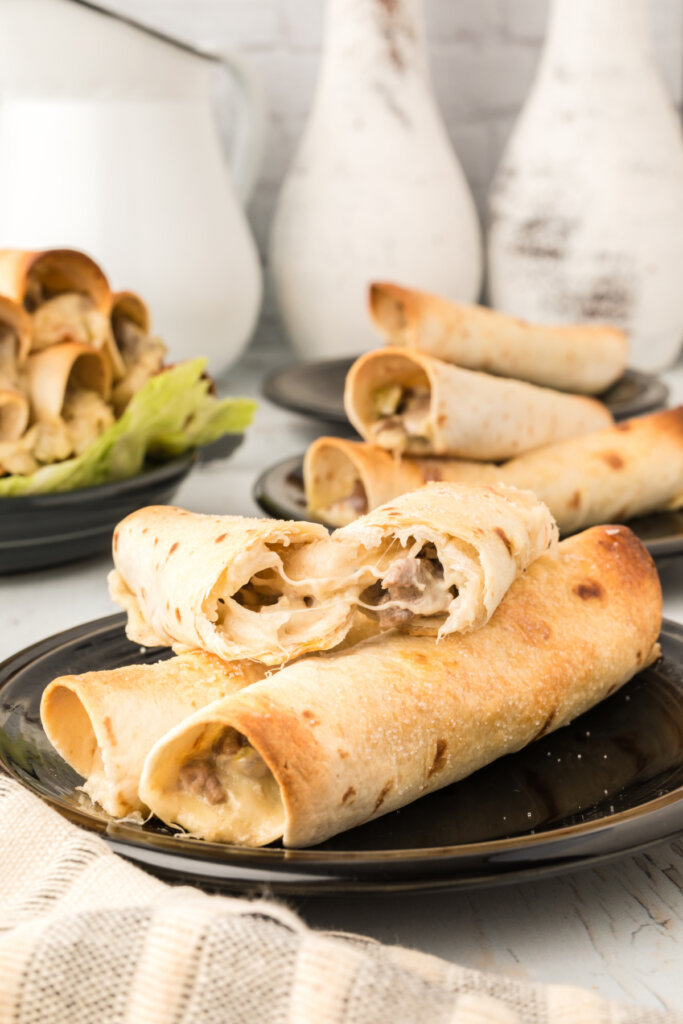 three philly cheesesteak taquitos on plate