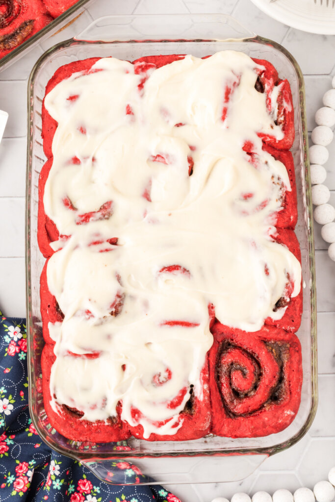 red velvet cinnamon rolls with cream cheese icing in pan