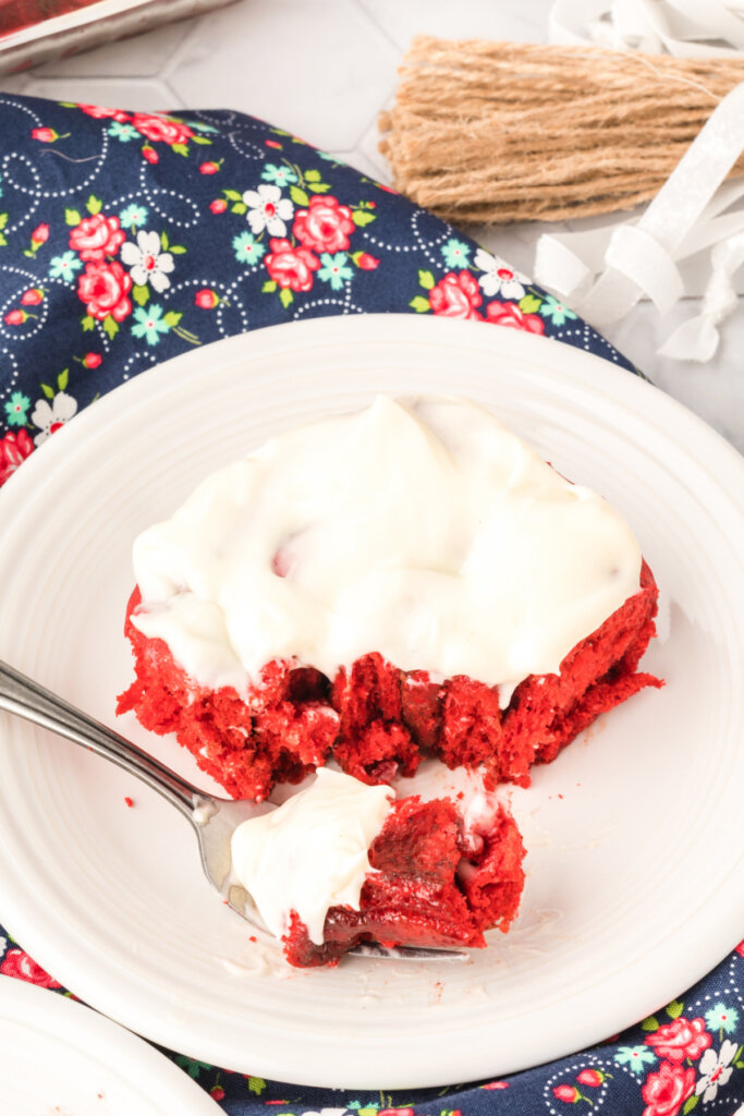 red velvet cinnamon roll on plate with bite on fork