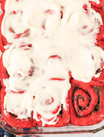 red velvet cinnamon roll swith cream cheese icing in glass pan