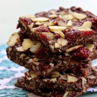 Crispy Dark Chocolate Cherry & Almond Bars stacked on a napkin.