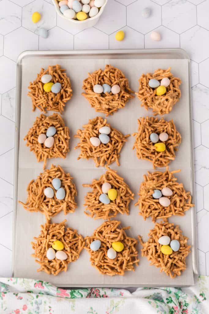 Bird Nest Cookies shaped on a lined baking sheet and topped with egg shaped candies