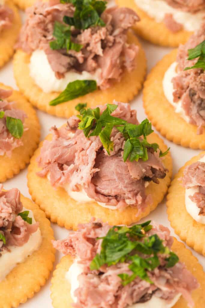 closeup of roast beef with horseradish cream cheese snack crackers on serving platter