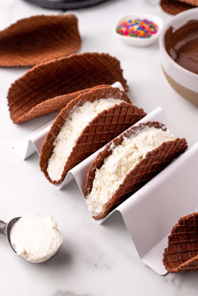 Chocolate taco shells filled with vanilla ice cream before dipping in melted chocolate.