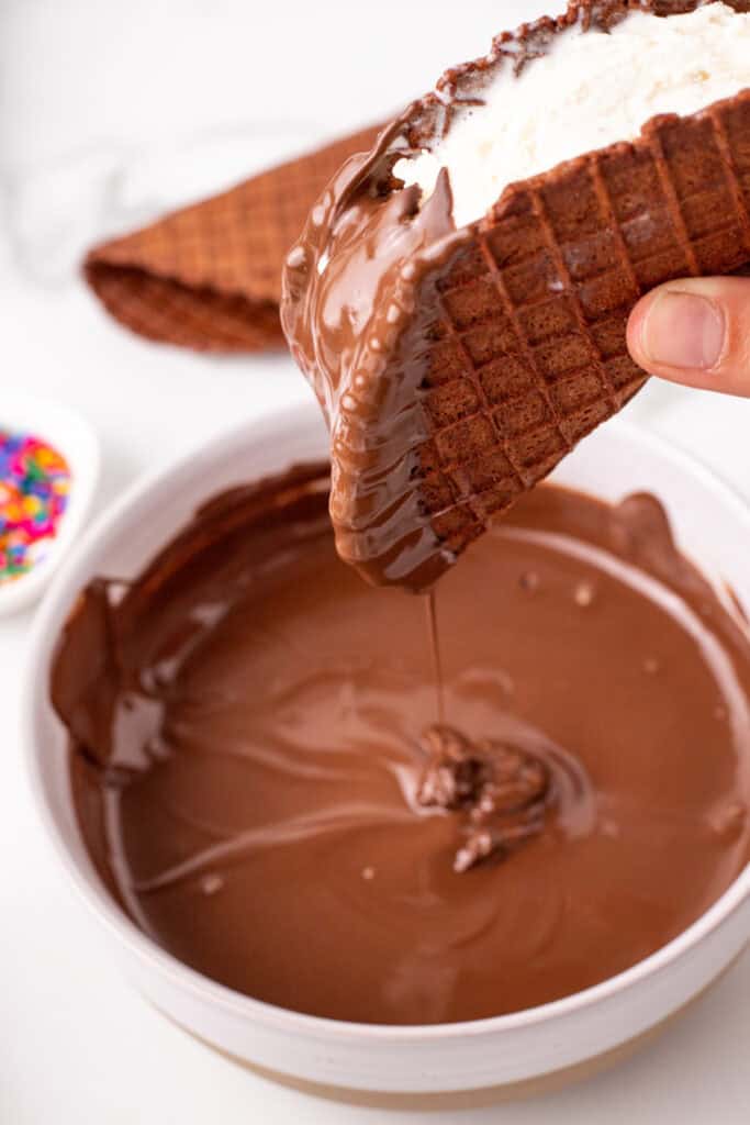 Vanilla ice cream taco dipped into melted chocolate coating for a homemade Choco-Taco recipe.