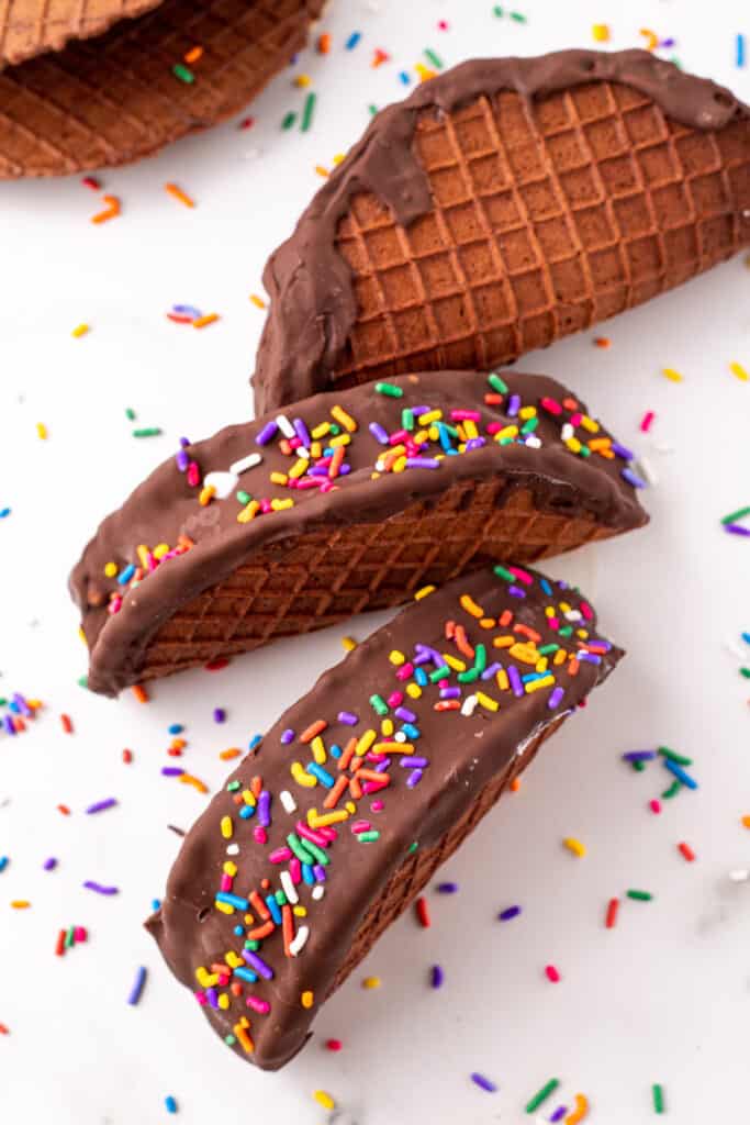 Homemade Choco-Tacos with vanilla ice cream, chocolate coating, and rainbow sprinkles.