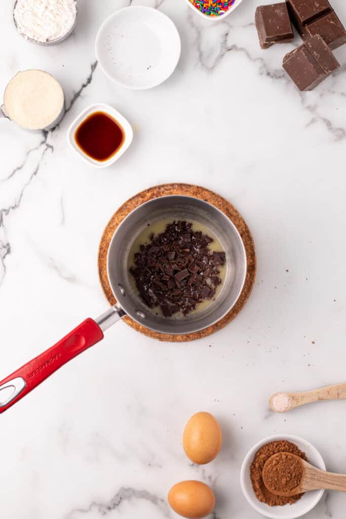 Chopped dark chocolate added to melted butter in a saucepan for the chocolate taco shell batter.