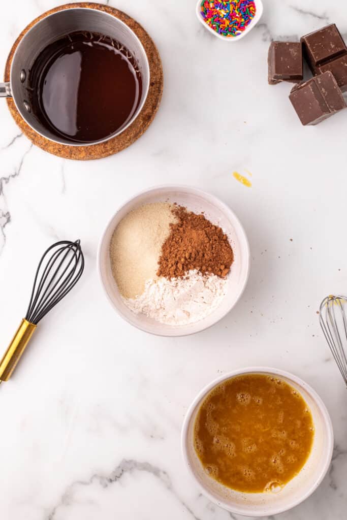 Flour, cocoa powder, and granulated sugar measured together to prepare the dry ingredients for chocolate taco shells.