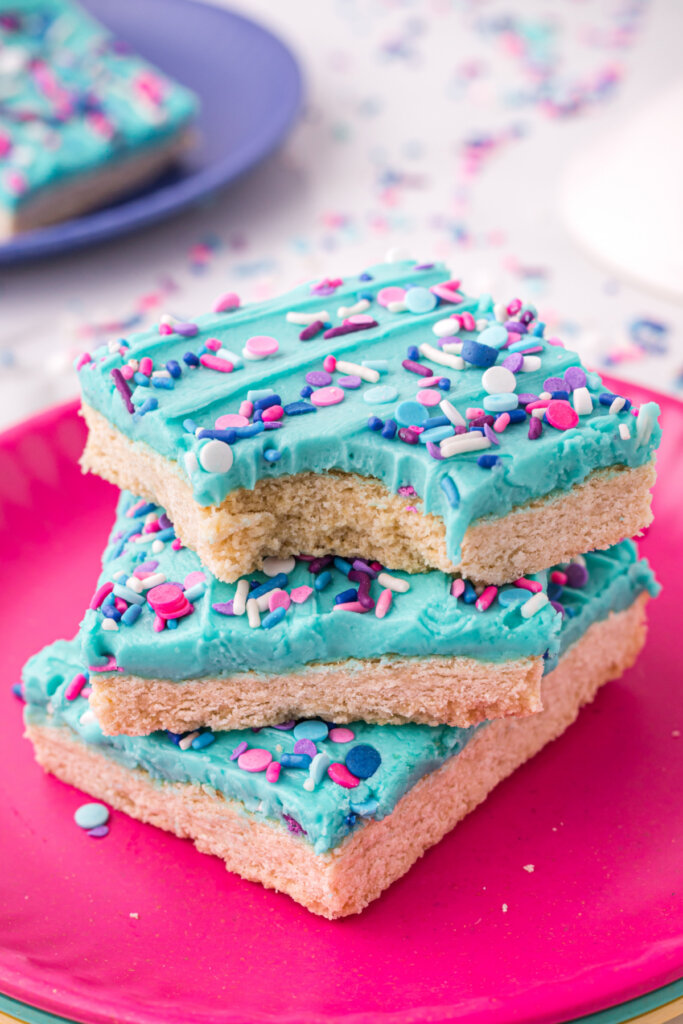 three sugar cookie bars stacked with a bite taken out of the top one