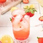 Square image of homemade Freckled Lemonade with fresh strawberry garnish and lemon slices.