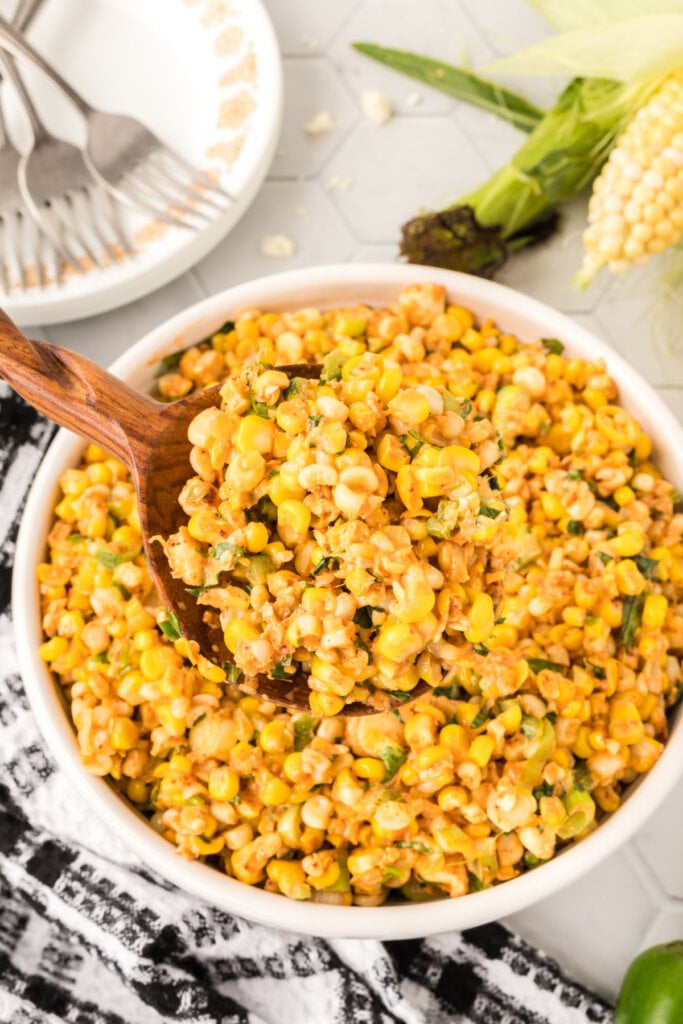 mexican street corn salad in bowl with wooden spoon