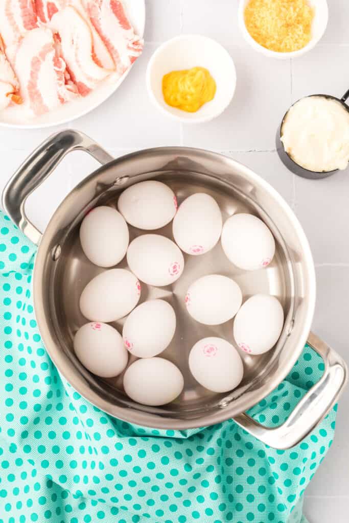 Place eggs in a saucepan and cover with cold water. Bring water to a boil and immediately remove from heat. Cover and let eggs stand in hot water for 18-20 minutes. Remove from hot water and cool by rinsing eggs under cold running water.