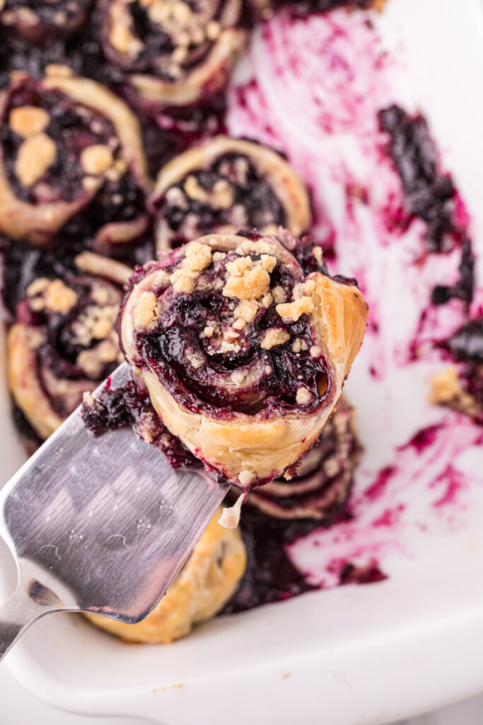 blueberry pie pinwheel on spatula over pan