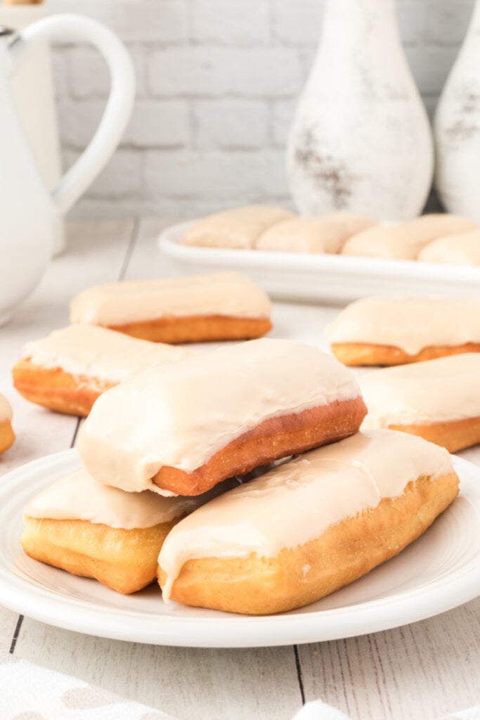 three maple bars stacked on plate