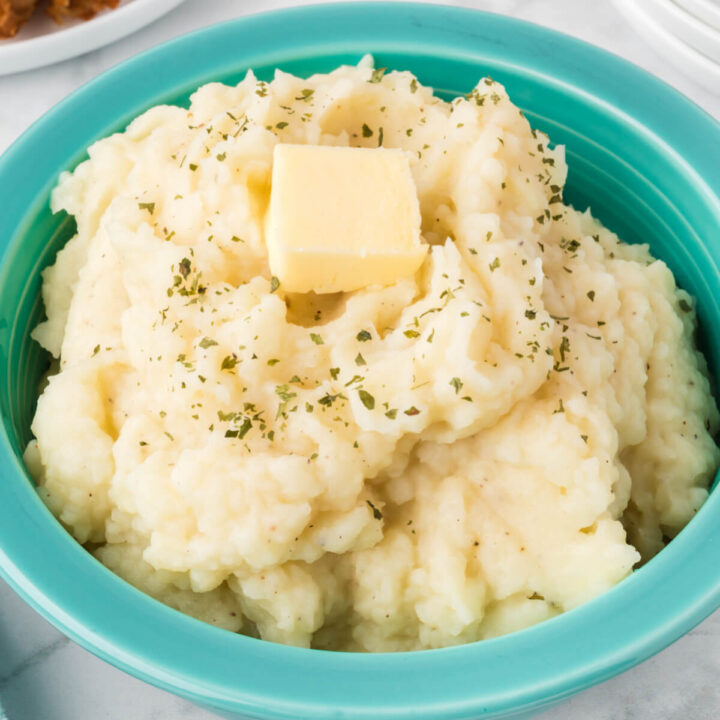 mashed potatoes topped with butter pat in bowl