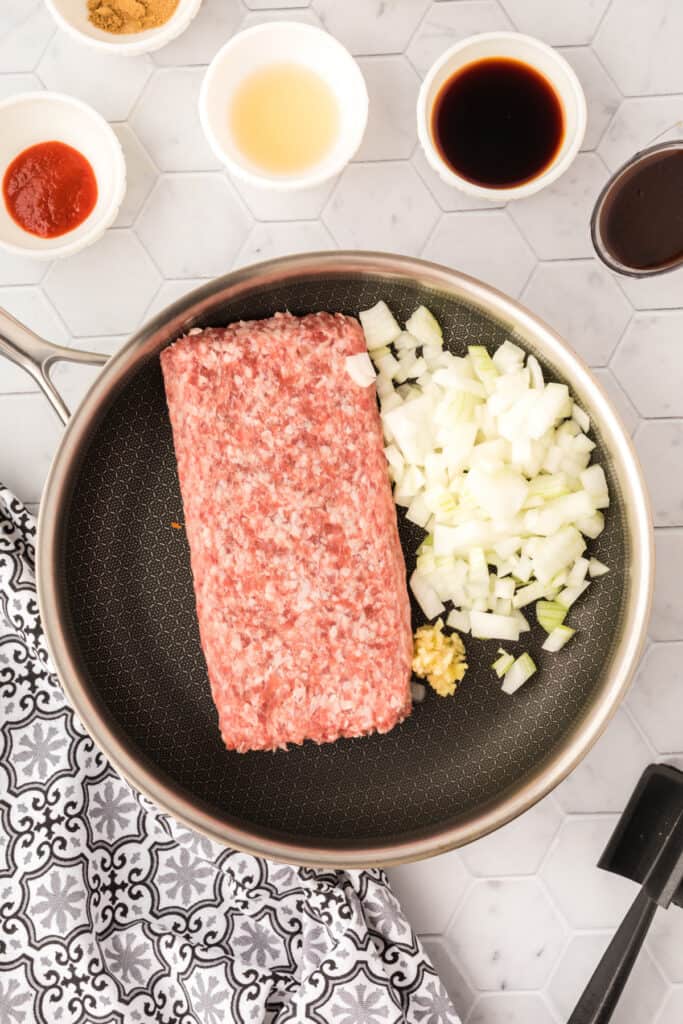 ground pork, chopped onion, and minced garlic in a skillet before cooking for Asian Pork Lettuce Wraps