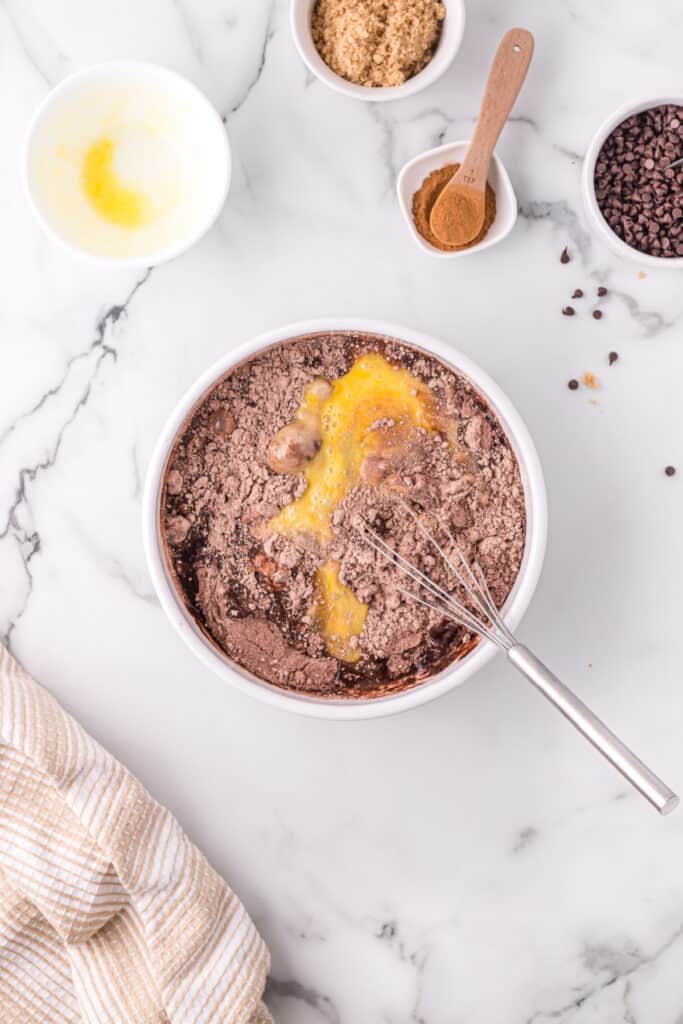 Adding beaten eggs to chocolate muffin batter