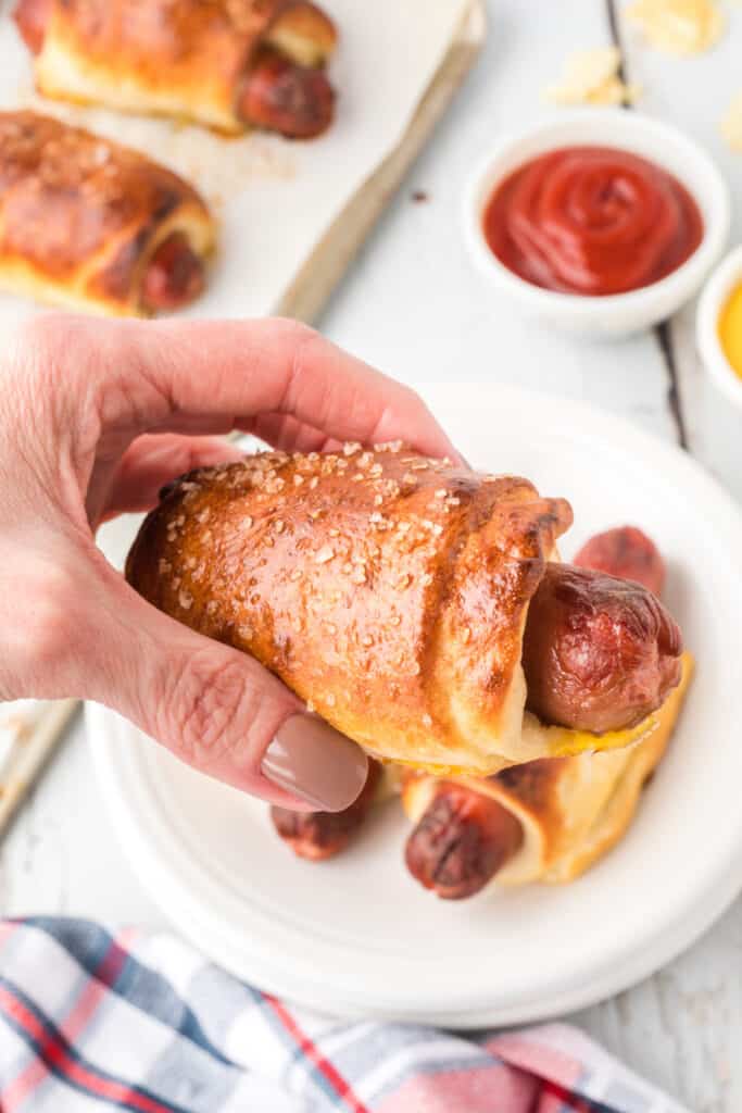 hand holding a pretzel dog