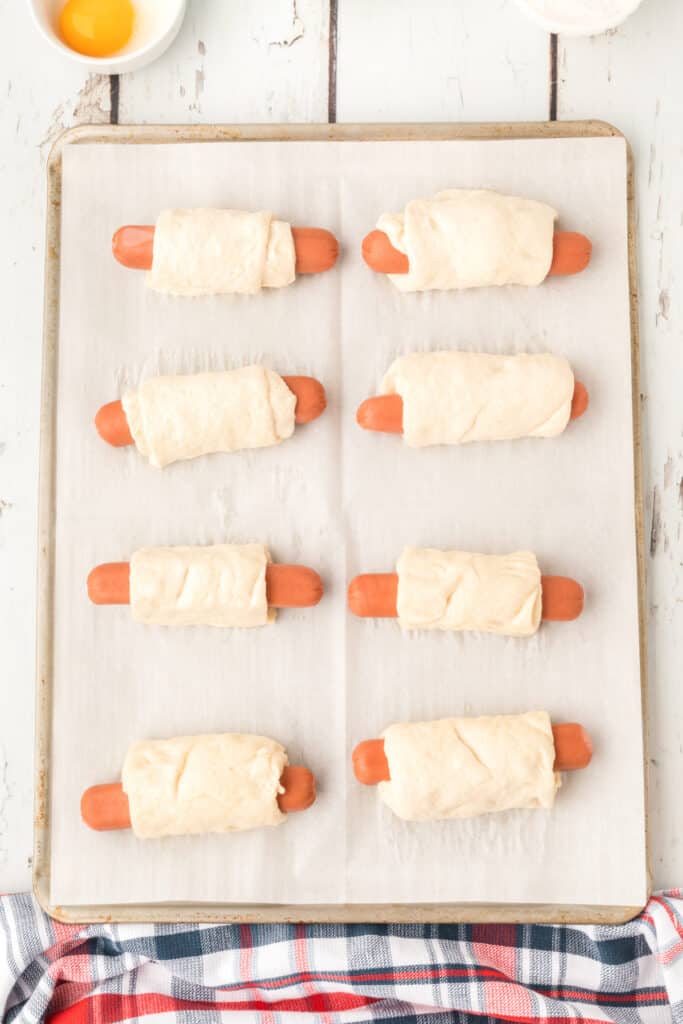 hot dogs on parchment paper lined baking sheet