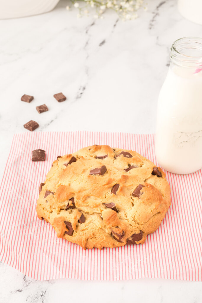 giant peanut butter cookie with glass bottle of milk