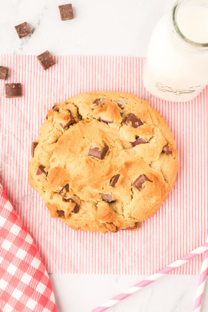 one giant peanut butter cookie with chocolate chunks on wax paper