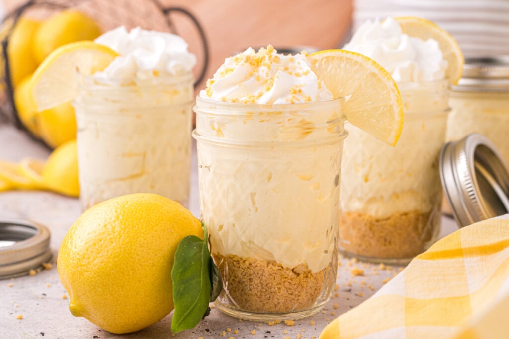 three jars filled with no-bake lemon cheesecake