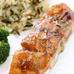 Dr Pepper Glazed Salmon on a white plate with rice pilaf.