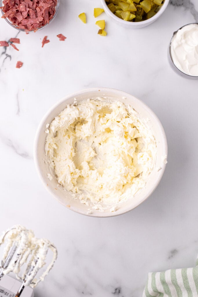 Cream cheese beaten until fluffy in a mixing bowl with other ingredients nearby