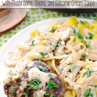 Italian Beef Patties with Mushrooms, Onions, and Balsamic Cream Sauce on a white plate.