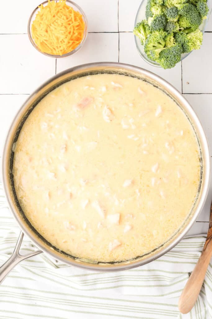 Creamy chicken and rice mixture simmering in a skillet for Cheesy Chicken Broccoli Rice Skillet