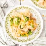 Square image of Cheesy Chicken Broccoli Rice Skillet served on a plate with broccoli, chicken, rice, and melted cheddar cheese