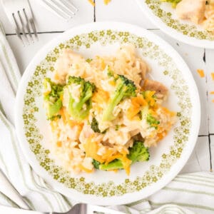 Square image of Cheesy Chicken Broccoli Rice Skillet served on a plate with broccoli, chicken, rice, and melted cheddar cheese