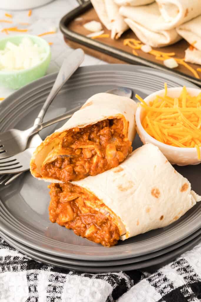 Cut Chili Cheese Burrito on a gray plate showing the beef, bean, cheese, and onion filling inside.
